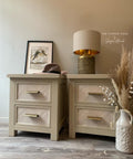 Dixie Belle Paint Burlap Chalk Mineral Paint is the perfect paint for any DIY project!
Bedside tables painted in Burlap Chalk Mineral Paint with faux wood tracing on the drawers. Staged with a gold lamp on one table and a hate with a picture frame on the other. A white jug vase with feathers and cotton inside.