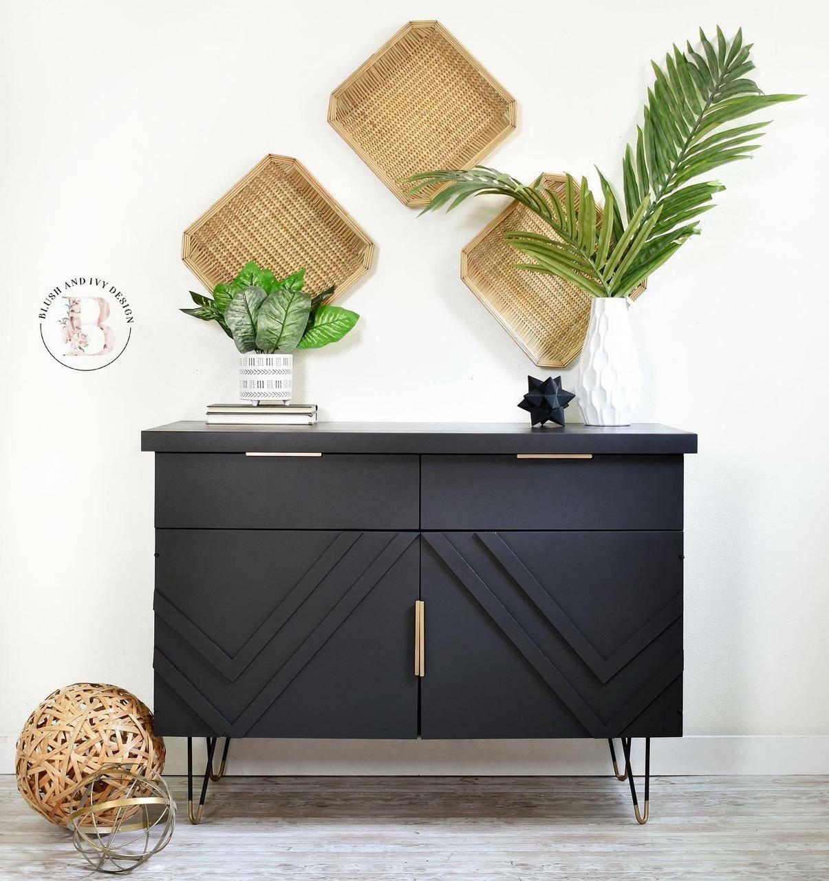 Dixie Belle Paint Caviar Chalk Mineral Paint is the perfect paint for any DIY project!
Entertainment center cabinet painted in Caviar Chalk Mineral Paint with gold hardware. Staged with woven trays mounted on the wall with two potted house plants on a white and gray wood floors.