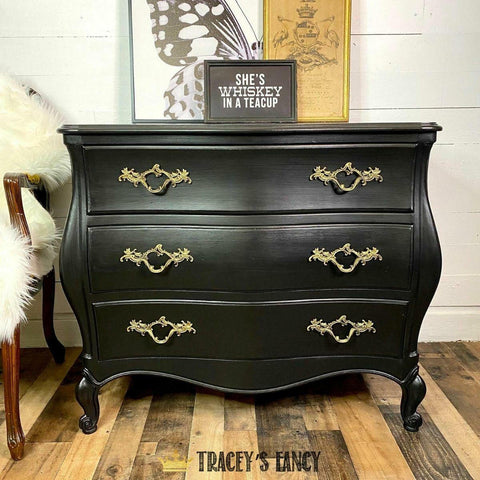 Dixie Belle Paint Caviar Chalk Mineral Paint is the perfect paint for any DIY project!
Dresser painted in Caviar Chalk Mineral Paint with gold hardware staged with a framed sign that reads " SHE'S WHISKEY IN A TEACUP" on the top.
