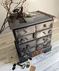Dixie Belle Paint Chocolate Chalk Mineral Paint is the perfect paint for any DIY project!
Steampunk style of a chest of drawers painted in Chocolate Chalk Mineral Paint with gear aplique on the drawers and the Steampunk Transfer all over piece as well. Staged with antique keys and branches with vintage photo around piece.