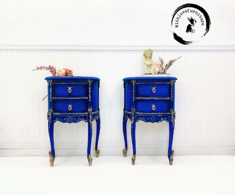 Dixie Belle Paint Cobalt Blue Chalk Mineral Paint is the perfect paint for any DIY project!
There are two side tables next to each other both painted with Cobalt Blue CMP.  They both have two draws and have Wood-U-Bend trim painted gold.  On top of the side table on the left has pretty dried flowers with colors of pink, peach and rose.  On the side table on the right there are dried flowers of Pink and green with a white statue of a little girl.