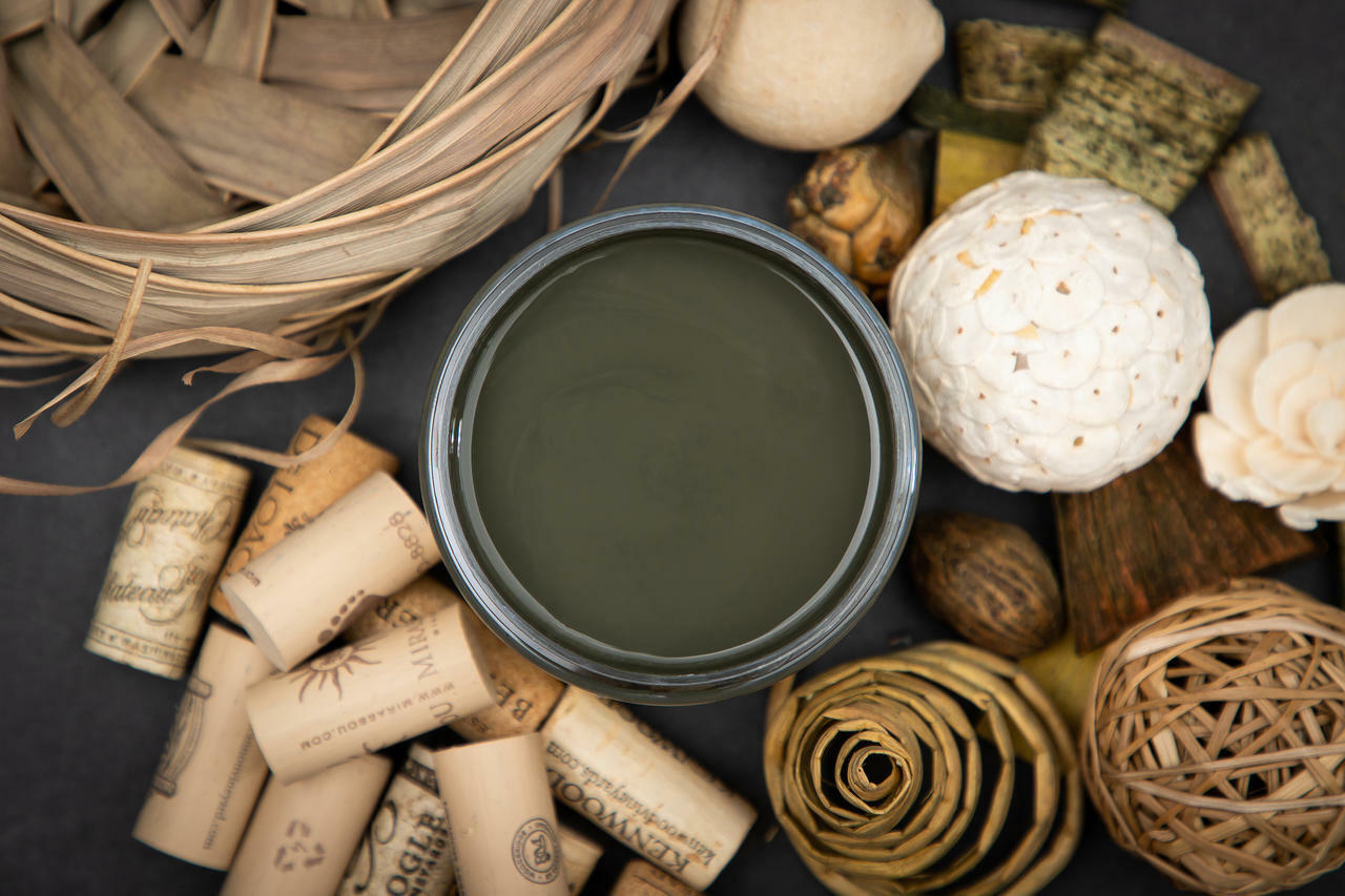 Dixie Belle Paint Collard Greens Chalk Mineral Paint is the perfect paint for any DIY project!
You are looking down on the Collard Green CMP so you can only see the paint in the can.  The paint is sitting on a black surface with corks, grass basket and grass balls and wooden chatskis surrounding it.