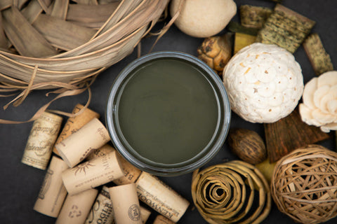 Dixie Belle Paint Collard Greens Chalk Mineral Paint is the perfect paint for any DIY project!
You are looking down on the Collard Green CMP so you can only see the paint in the can.  The paint is sitting on a black surface with corks, grass basket and grass balls and wooden chatskis surrounding it.