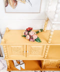Dixie Belle Paint Daisy Chalk Mineral Paint is the perfect paint for any DIY project! An entertainment center that is painted in daisy and is staged with flowers and a pair of heels.