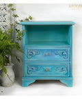 Dixie Belle Paint Dixie Belle Blue Chalk Mineral Paint is the perfect paint for any DIY project!
This is a side table for a bedroom.  There  is an open area on top and two drawers on the bottom.  It  is painted in Dixie Belle Blue CMP.  It is staged with plants and a china wall.