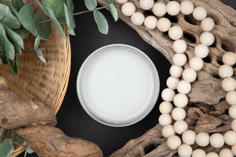 Dixie Belle Paint Driftwood Chalk Mineral Paint is the perfect paint for any DIY project! Open jar of Driftwood Chalk Mineral Paint staged with driftwood, greenery, and wooden beads.