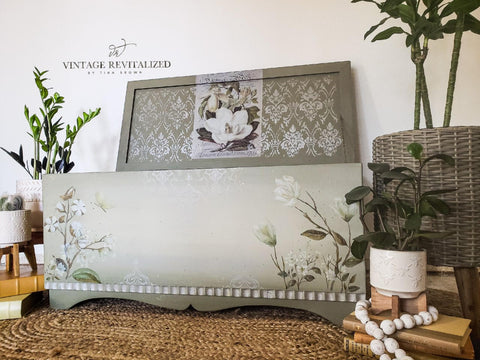 Dixie Belle Paint Driftwood Chalk Mineral Paint is the perfect paint for any DIY project!
Gray chalk painted chest makeover. Magnolia Garden rub on furniture transfer placed on the front sides and inside lid of the chest. Royal Damask stencil stenciled on with white chalk paint. Staged with three white pots, stacked on books, containing green plants and white beads wrapped around one of the pots.