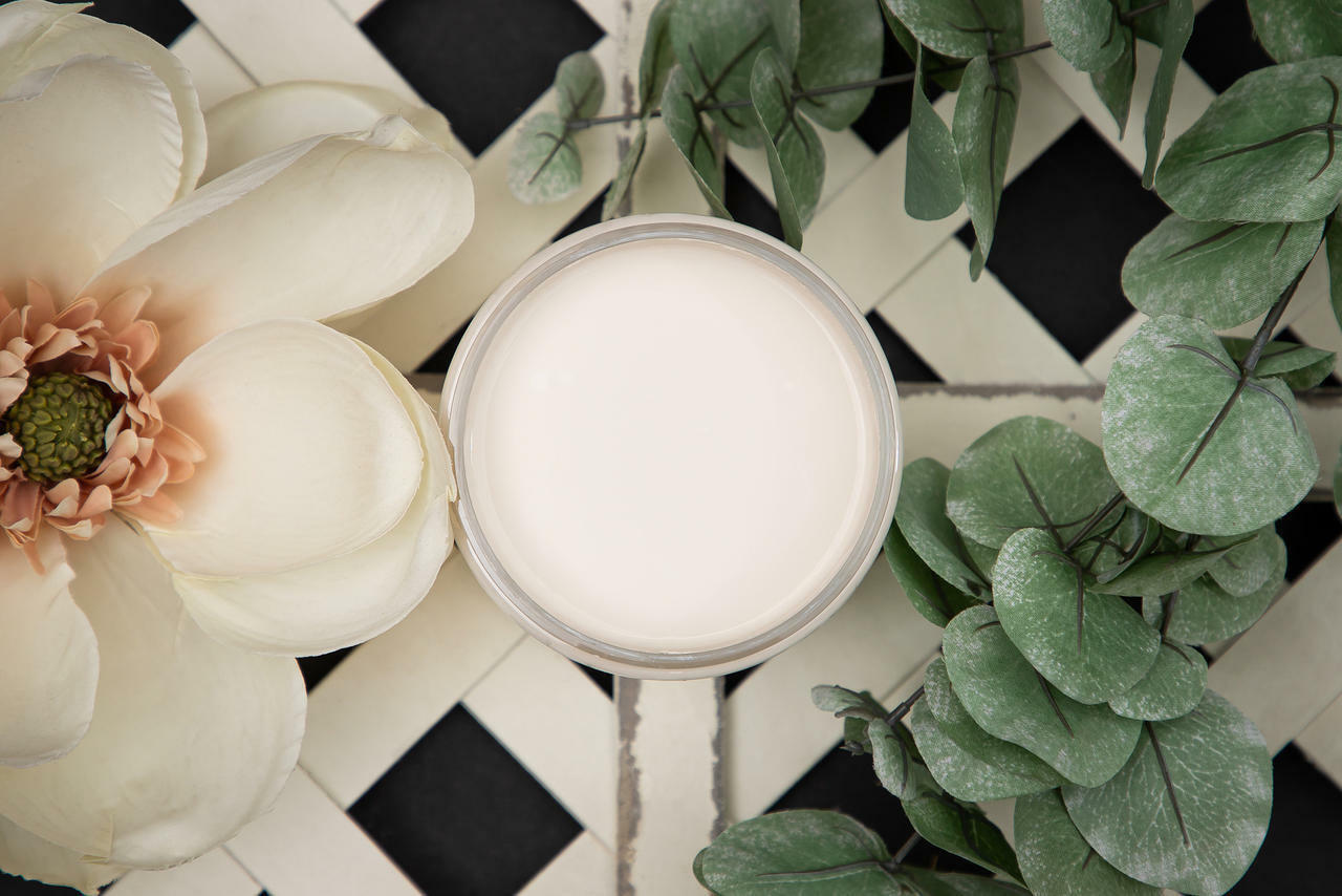 Dixie Belle Paint Drop Cloth Chalk Mineral Paint is the perfect paint for any DIY project! Open jar of white chalk mineral paint on top of a trellis with a large white faux flower and faux eucalyptus .