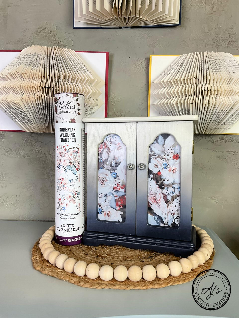 Dixie Belle Paint Drop Cloth Chalk Mineral Paint is the perfect paint for any DIY project! White and blue chalk painted jewelry box with a Bohemian Wedding rub on furniture transfer. Staged on a woven placemat with beads on the edges and three open books with folded pages.