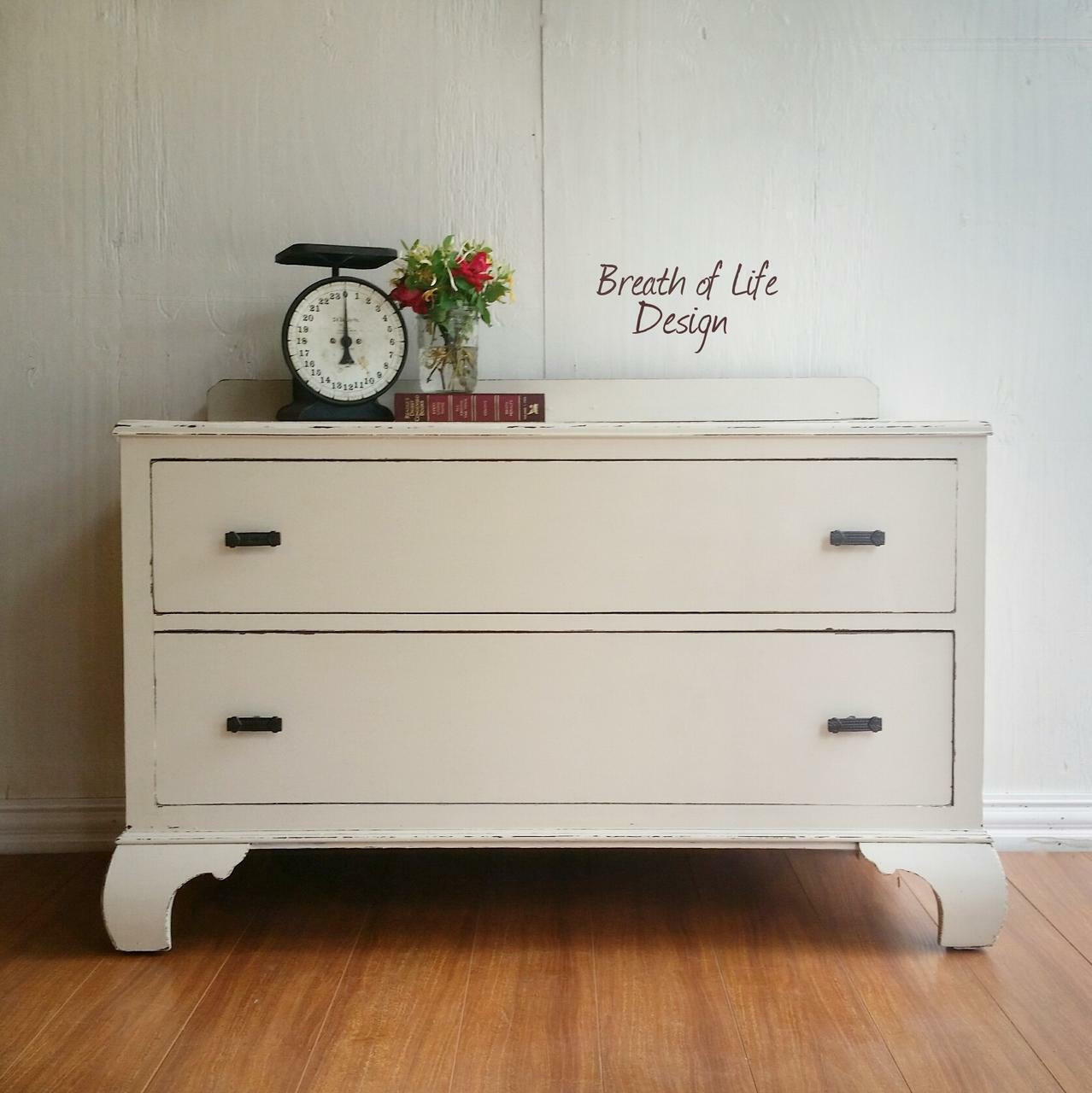 Dixie Belle Paint Drop Cloth Chalk Mineral Paint is the perfect paint for any DIY project! White chalk painted chest with drawers with black handles. Staged with a large vintage food scale and a vase with red roses placed on a book.
