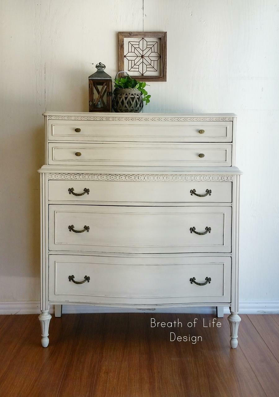 Dixie Belle Paint Drop Cloth Chalk Mineral Paint is the perfect paint for any DIY project! White chalk painted dresser makeover staged with a vintage lantern, a woven pot holder and a wood frame with a metal geometric design inside.