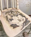 Dixie Belle Paint Easy Peasy™ Spray Wax 8oz. White chalk painted chair with the Magnolia Garden rub on furniture transfer applied on the seat of the chair.