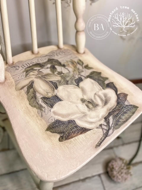Dixie Belle Paint Easy Peasy™ Spray Wax 8oz. White chalk painted chair with the Magnolia Garden rub on furniture transfer applied on the seat of the chair.