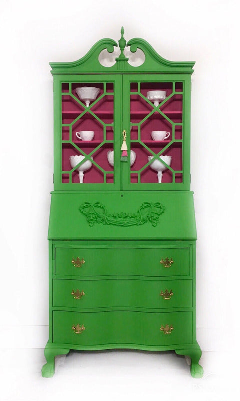 Dixie Belle Paint Evergreen Chalk Mineral Paint is the perfect paint for any DIY project! Green armoire makeover with gold handles containing white china. The inside is painted in a bright pink.