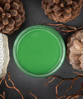 Dixie Belle Paint Evergreen Chalk Mineral Paint is the perfect paint for any DIY project! Open jar of Evergreen Chalk Mineral Paint. 3 pine cones surrounding the open jar with a burlap and lace ribbon laying near the jar.