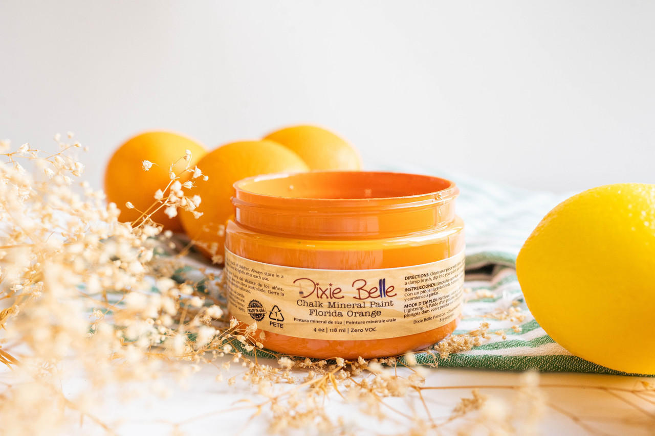 Dixie Belle Paint Florida Orange Chalk Mineral Paint is the perfect paint for any DIY project! A side view of a 4 oz container of Florida Orange Chalk paint with oranges for decoration.