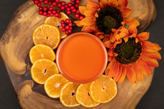 Dixie Belle Paint Florida Orange Chalk Mineral Paint is the perfect paint for any DIY project! An overhead view of an open container of Florida Orange Chalk paint with slices of oranges next to the container for decoration.