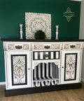 Dixie Belle Paint Grunge Glaze 
Beautiful fireplace white and black credenza with the Grunge Glaze inside the wood applique. Staged with white candle pedestaled and greenery on top of piece. on a green wall background.