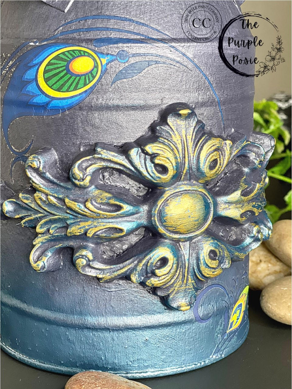 Dixie Belle Paint Hi Ho Silver Glaze
a close up image of a vintage milk can painted in a blend of Chalk Mineral Paint in Aubergine, Antebellum Blue, Peacock with the WoodUbend  applique in 1339 using the Hi Ho Silver Glaze on the edges on applique.