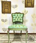 Dixie Belle Paint Holy Guacamole Chalk Mineral Paint is the perfect paint for any DIY project!
An antique chair with mint green cushion painted in Holy Guacamole Chalk Mineral Paint. Staged on distressed wood floors and two bronze wall decor hanging on the wall.