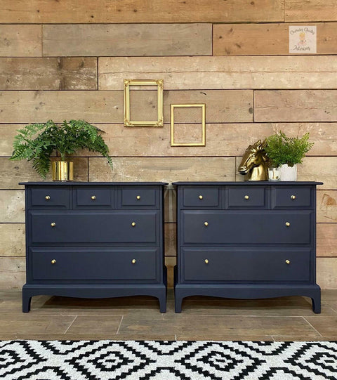 Dixie Belle Paint In the Navy Chalk Mineral Paint is the perfect paint for any DIY project!
Twin dresser set painted in In the Navy Chalk Mineral Paint along with gold hardware. Staged with gold frames on the wall hanging above the pieces, a gold houseplant pot, and a gold horse head statue on one of the dressers.