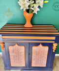 Dixie Belle Paint In the Navy Chalk Mineral Paint is the perfect paint for any DIY project!
A Drink cabinet painted with In the Navy Chalk Mineral Paint along with orange stripes and the Greek Key - Stencil on the door panel.