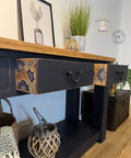Dixie Belle Paint In the Navy Chalk Mineral Paint is the perfect paint for any DIY project!
A console table painted in In the Navy Chalk Mineral Paint with black hardware and a natural wood top, two drawers are open showing Embroidered Lotus - Transfer on the side panel of the drawer. Staged with decor like potted plants, wooden and woven baskets and a picture frame on top of the piece.