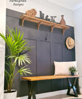 Dixie Belle Paint In the Navy Chalk Mineral Paint is the perfect paint for any DIY project!
A painted wall in a mudroom using  In the Navy Chalk Mineral Paint staged with a wooden shelf and a wooden bench with black legs, a white pillow and potted plant on the bench.