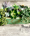 Dixie Belle Paint Kudzu Chalk Mineral Paint is the perfect paint for any DIY project!
A wooden box painting with Kudzu Chalk Mineral Paint and staged with an assortment of faux succulents inside box.