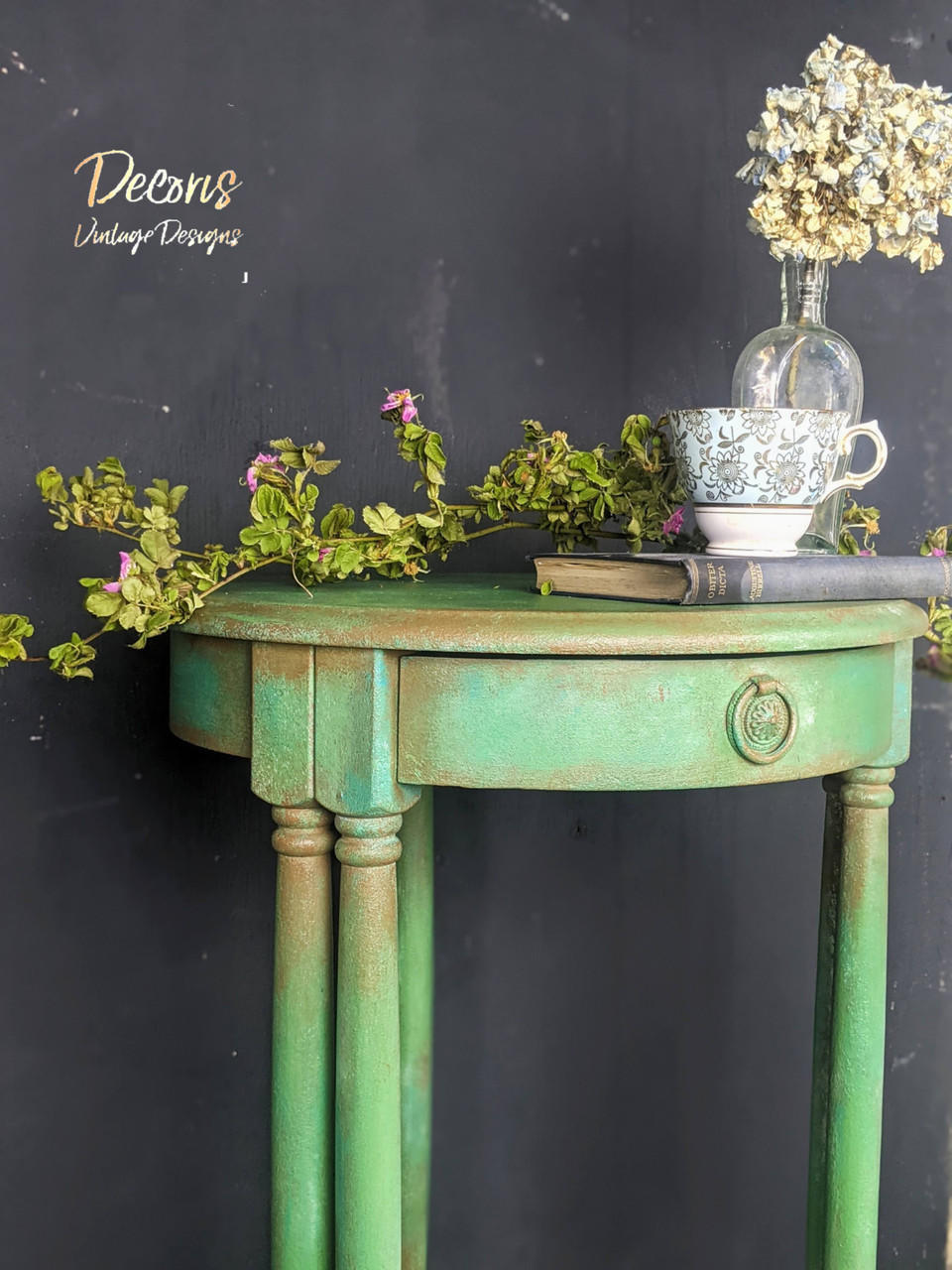 Dixie Belle Paint Kudzu Chalk Mineral Paint is the perfect paint for any DIY project!
An Entryway table painted in Kudzu Chalk Mineral Paint with Pinecone CMP around the edges and the top of the posts. Staged with a book and teacup as well as greenery on top of the table.
