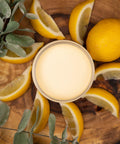 Dixie Belle Paint Lemonade Chalk Mineral Paint is the perfect paint for any DIY project!
Top view of an opened container of Lemonade Chalk Mineral Paint staged with lemon slices,a whole lemon and an eucalyptus branches on top of a round wooden board.