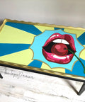 Dixie Belle Paint Limeade Chalk Mineral Paint is the perfect paint for any DIY project!
A scalloped edge table hand painted pop art using Peacock, Dixie Belle Blue, Limeade Chalk Mineral Paints with hand painted red lips opened with a cherry.