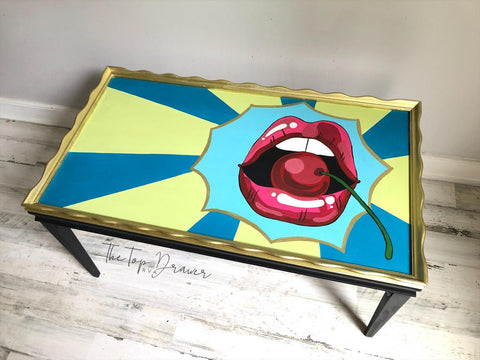 Dixie Belle Paint Limeade Chalk Mineral Paint is the perfect paint for any DIY project!
A scalloped edge table hand painted pop art using Peacock, Dixie Belle Blue, Limeade Chalk Mineral Paints with hand painted red lips opened with a cherry.