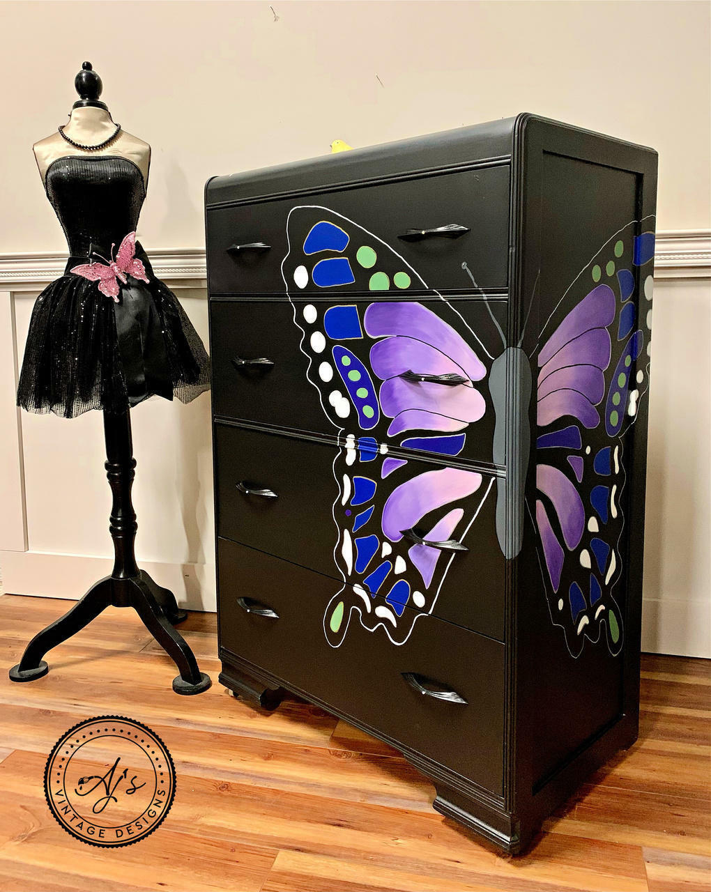Dixie Belle Paint Lucky Lavender Chalk Mineral Paint is the perfect paint for any DIY project!
Black dresser with a hand painted butterfly split between the front and side of dresser. Lucky Lavender Chalk Mineral Paint is seen on the inside of the wing to the butterfly. Staged with a body mannequin with a black tutu dress and pink  butterfly.