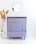 Dixie Belle Paint Lucky Lavender Chalk Mineral Paint is the perfect paint for any DIY project!
Beautiful white minimalistic stage with a dresser painted in Lucky Lavender Chalk Mineral Paint and gold hardware