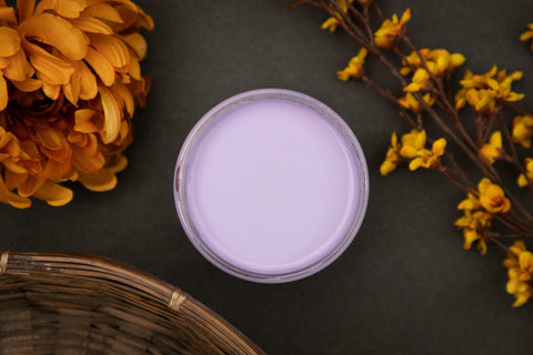 Dixie Belle Paint Lucky Lavender Chalk Mineral Paint is the perfect paint for any DIY project!
Opened container of Lucky Lavender CMP Staged with flowers and a woven basket around it on a black background.