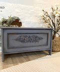 Dixie Belle Paint Manatee Gray Chalk Mineral Paint is the perfect paint for any DIY project! Chalk Painted Blanket box In a Dark Gray color. Staged with a wooden box with some trailing plants inside.