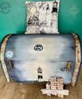 Dixie Belle Paint Manatee Gray Chalk Mineral Paint is the perfect paint for any DIY project! Blue Gray Chalk Painted Trunk with Nautical Rub on Transfers. Staged with a nautical lighthouse pillow and a welcome sign.