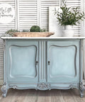 Dixie Belle Paint Manatee Gray Chalk Mineral Paint is the perfect paint for any DIY project! Blue Gray Chalk Mineral Painted cabinet. Staged with a vase with florals.