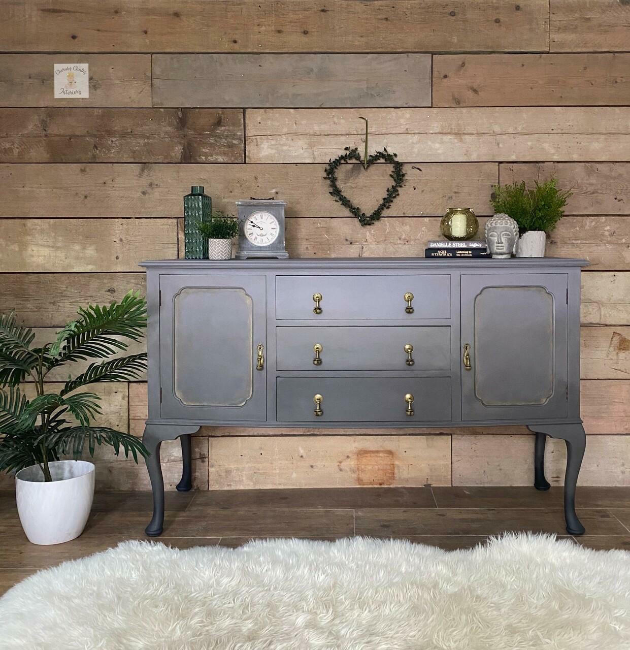 Dixie Belle Paint Mason Dixon Gray Chalk Mineral Paint is the perfect paint for any DIY project! Gray and Black Ombre style Chalk painted Long Entry desk. Staged with a potted plant besides it, a heart wreath on the wall. Also staged with a clock, some books, vases plants and a buddha head.