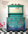 Dixie Belle Paint Mermaid Tail Chalk Mineral Paint is the perfect paint for any DIY project! Dark blue, Pink and teal Ombre Chalk Painted dresser with mirror. Staged with a glass vase and some pink flowers.