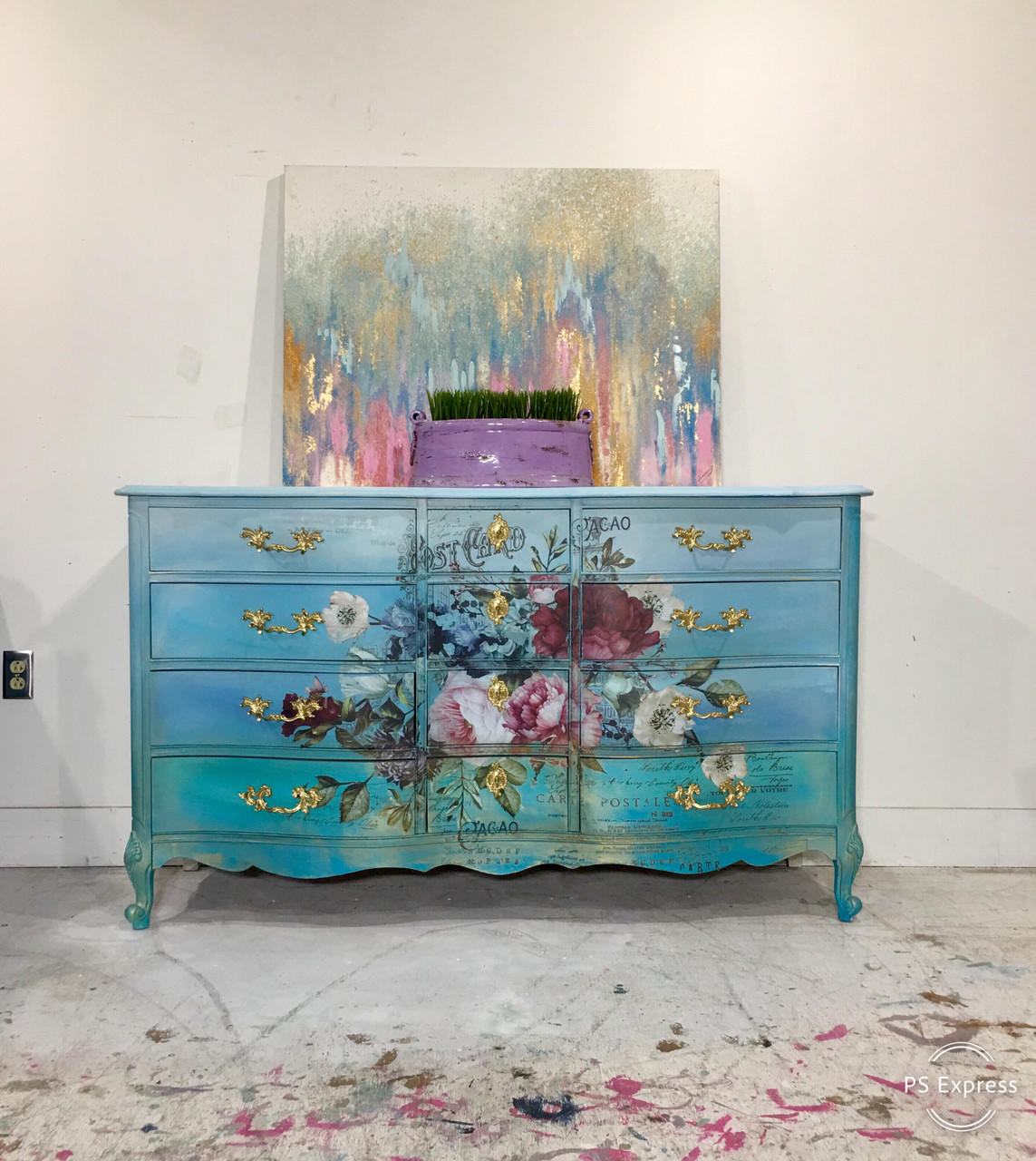 Dixie Belle Paint Mermaid Tail Chalk Mineral Paint is the perfect paint for any DIY project! Teal Chalk painted Ombre dresser with Floral Rub on transfers. Staged with a colorful picture and a purple vase with grass in it.