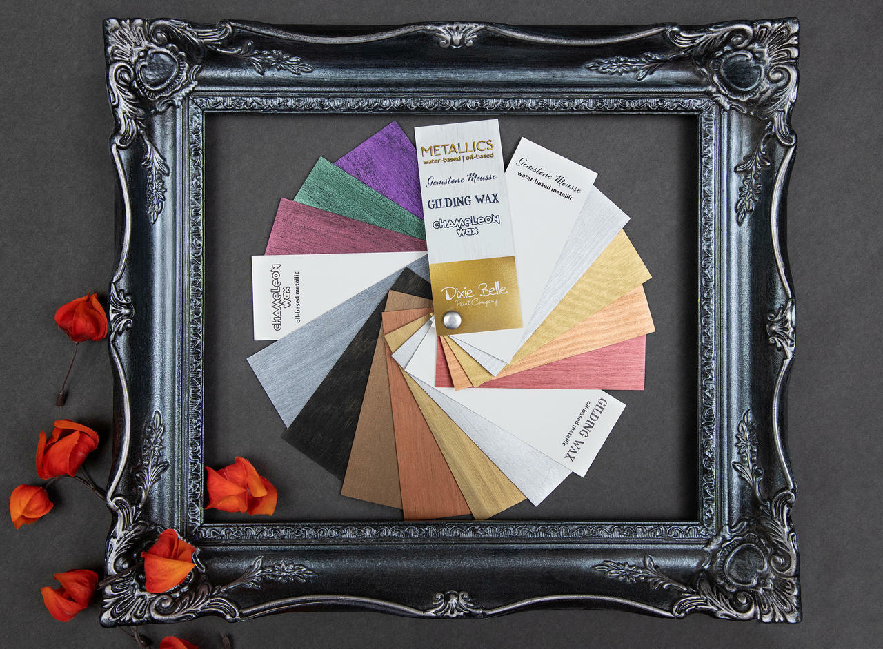 Dixie Belle Paint Metallics Fan Deck. Moonshine Metallic Chalk Mineral Paint painted on cards to show color far way inside black picture frame with red flowers.