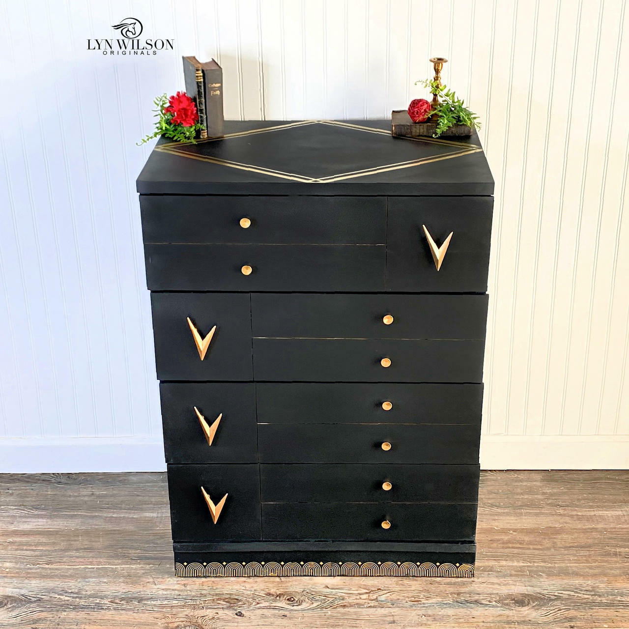 Dixie Belle Paint Midnight Sky Chalk Mineral Paint is the perfect paint for any DIY project! Black Chalk Mineral painted Mid Century dresser with gold accents and hardware. Staged with a red flower and book with candle stick.
