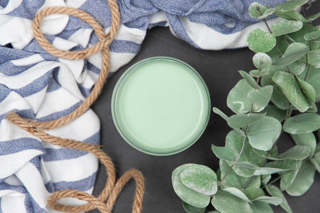Dixie Belle Paint Mint Julep Chalk Mineral Paint is the perfect paint for any DIY project! Top view of Mint Julep Chalk Mineral Paint with a blue and white stripe towel, a rope and a plant staged around it.