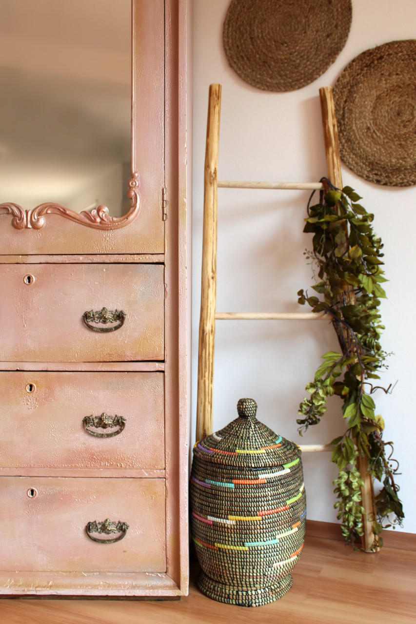 Moonshine metallic is the perfect paint to add shimmer and shine to your chalk painted furniture.  Armoire painted in pink moonshine metallic chalk mineral paint. Staged next to a blanket ladder, a wicker basket and greenery.