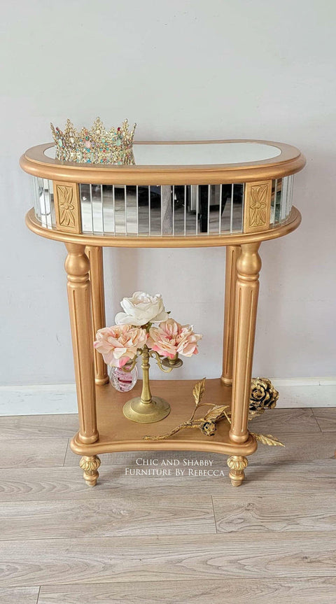 Metallic Gold Moonshine metallic is the perfect paint to add shimmer and shine to your chalk painted furniture. Gold moonshine metallic end table with mirrors on the side and on top. Staged with a crown , a gold vase and pink flowers.