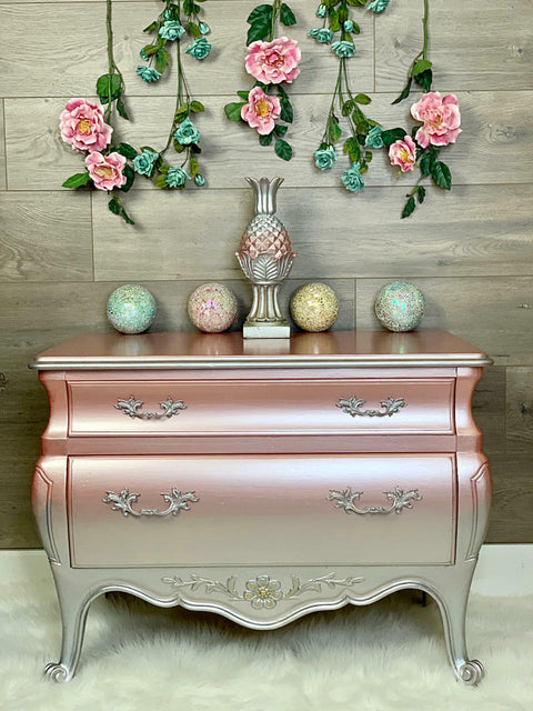 Silver Bullet Moonshine metallic is the perfect paint to add shimmer and shine to your chalk painted furniture. Pink and purple ombre moonshine metallic dresser. Staged with flowers, colored balls and a decorative acorn statue.