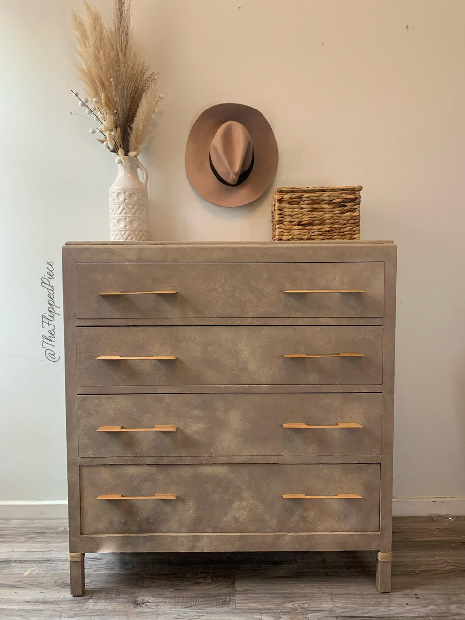 Dixie Belle Paint Mud Puddle Chalk Mineral Paint is the perfect paint for any DIY project!
Vintage style dresser painted in Dixie Belle Paint Mud Puddle Chalk Mineral Paint. Staged with a hat, wicker basket, and a white vase with faux wheat plants.