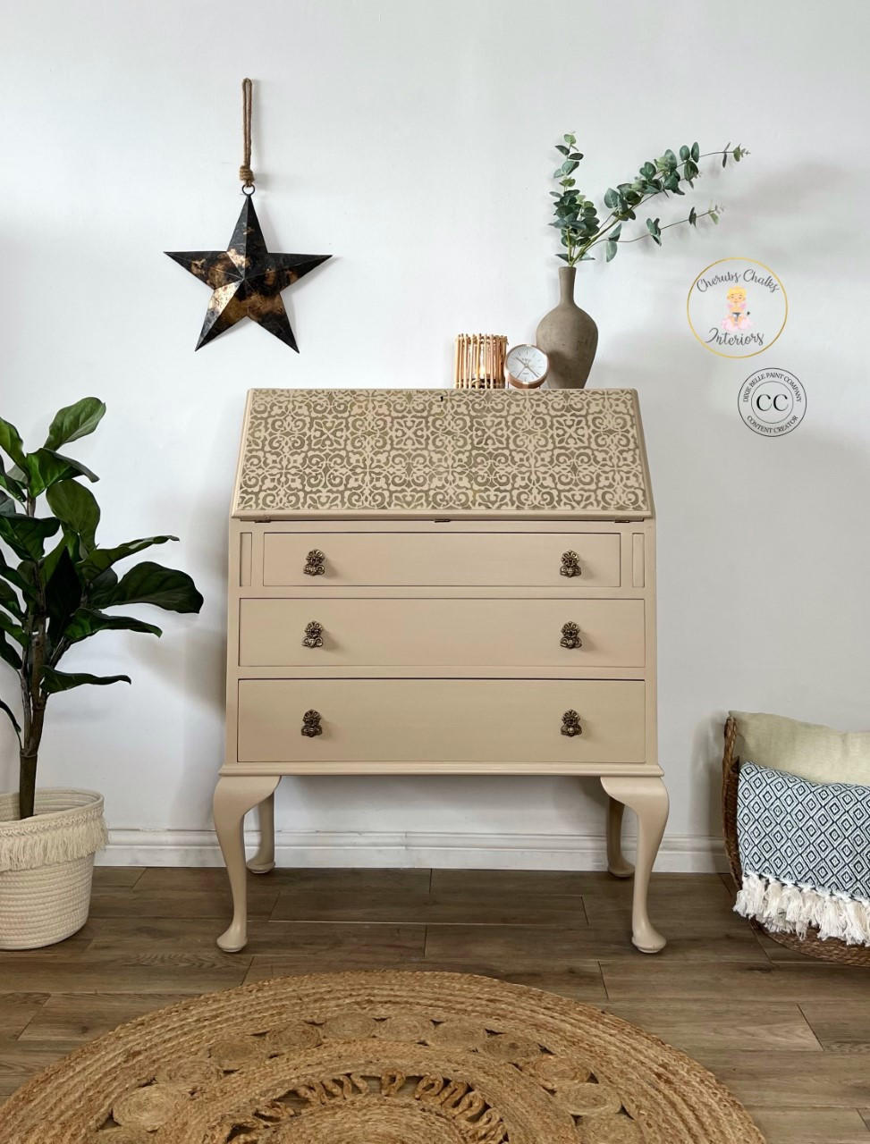 Dixie Belle Paint Mud Puddle Chalk Mineral Paint is the perfect paint for any DIY project!
Secretary desk painted in Dixie Belle Paint Mud Puddle Chalk Mineral Paint with a scroll stencil on the top. Staged with potted plants.